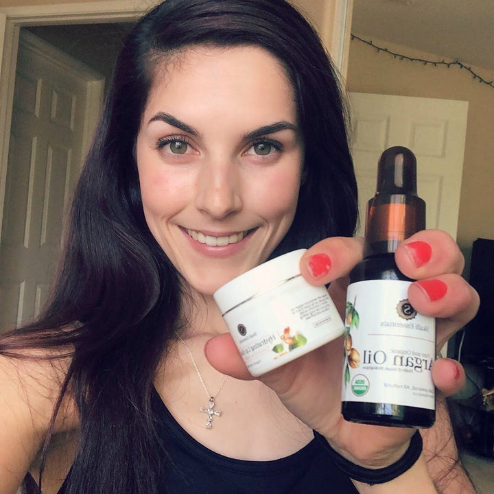 Woman smiling and holding organic, natural, and gluten-free skincare products: natural Moroccan argan oil and pure lip balm