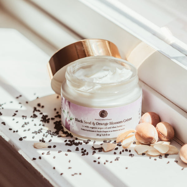 Organic skin cream with black seed oil, lavender flower water, and aloe vera for acne scar reduction, soothing, and deep skin hydration.