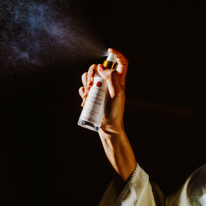 Hand spraying Skalli Essentials Moroccan Rose Water, showcasing its fine mist in use, highlighting the product’s refreshing application.