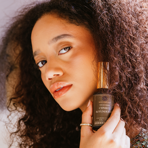 Close-up of a model using Skalli Essentials Cyperus Rotundus Oil, a pure Moroccan beauty oil that hydrates the skin and naturally slows unwanted hair regrowth.