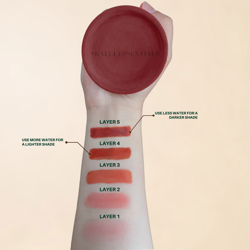Swatching organic lip color layers with a clay pot for customizable shades, using natural ingredients for a healthy, non-toxic lip care.