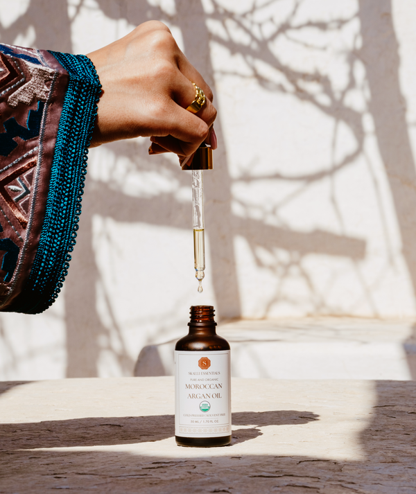 Close-up of Skalli Essentials Argan Oil dropper bottle, ideal for nourishing and hydrating skin and hair with organic Moroccan Argan Oil.