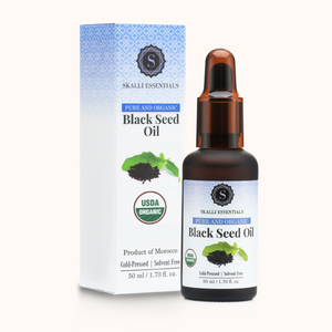 A 50ml bottle of USDA Organic Black Seed Oil from Skalli Essentials with a clear dropper, shown with its packaging, emphasizing its purity and solvent-free formula.