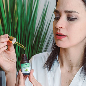 Model applying Skalli Essentials Moroccan Prickly Pear Seed Oil with a dropper, demonstrating its lightweight texture and hydrating, anti-aging benefits.